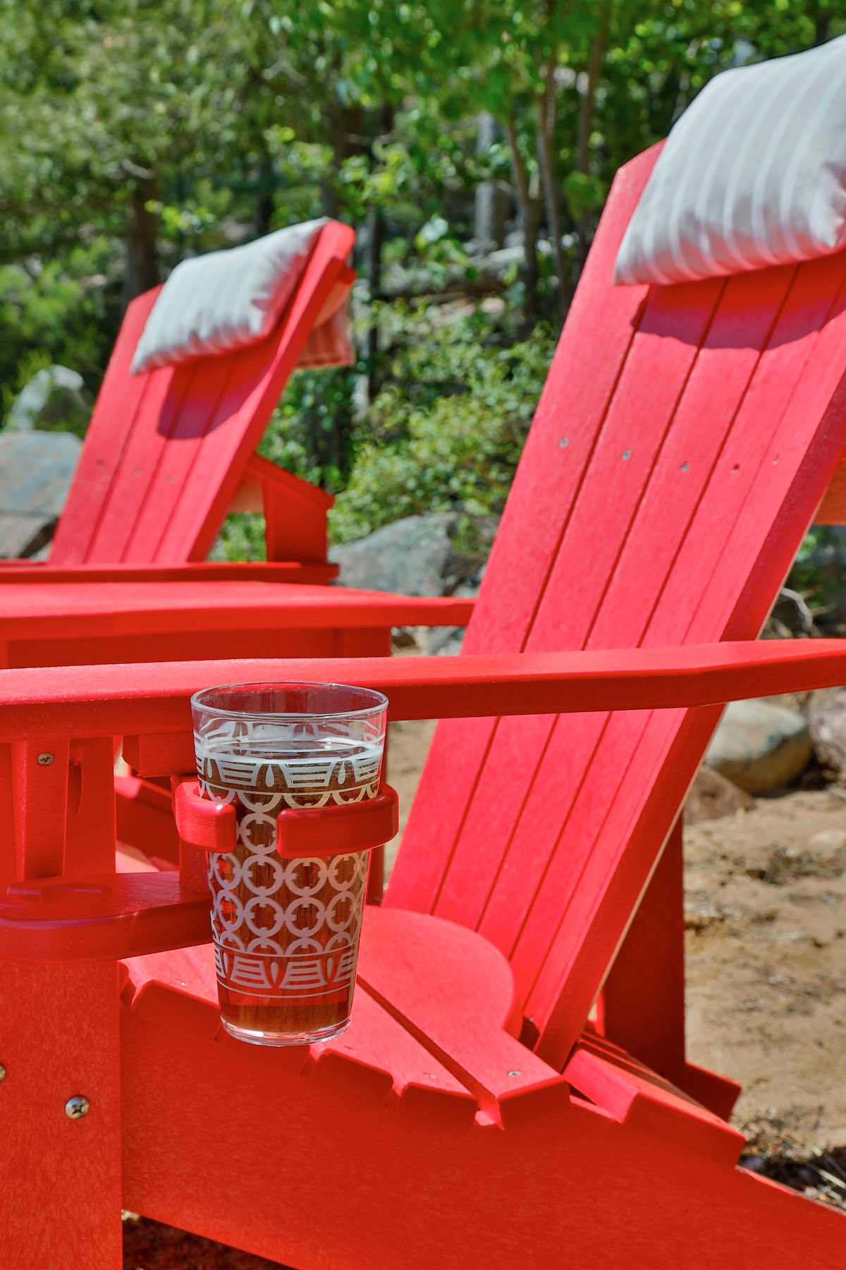 glass in cup holder of red patio chair